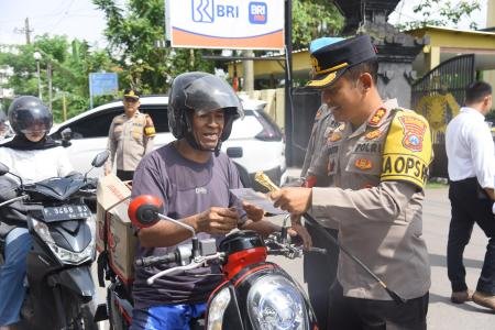 Kapolres Bondowoso membagikan brosur bagi pengguna jalan dalam operasi